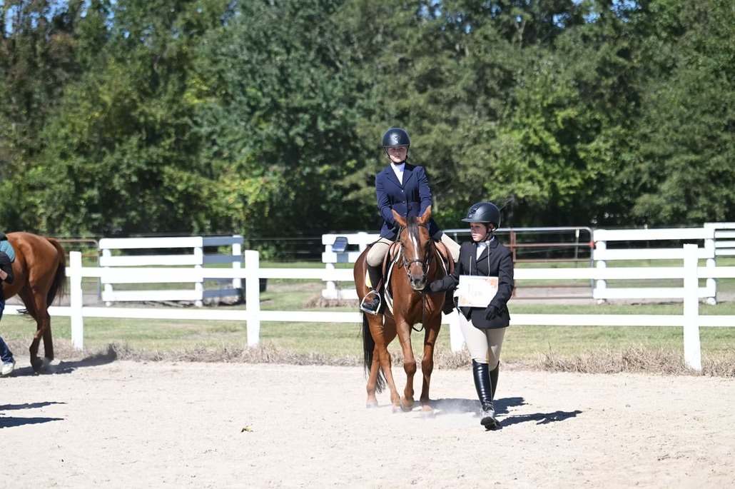 woman riding horse and another woman leading the horse